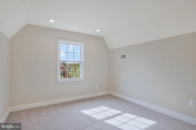 bonus room with visible vents, lofted ceiling, and light colored carpet