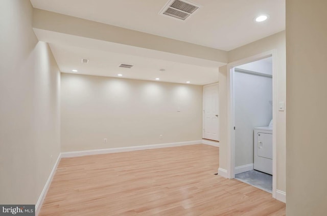 basement with washer / dryer, baseboards, light wood-style floors, and visible vents