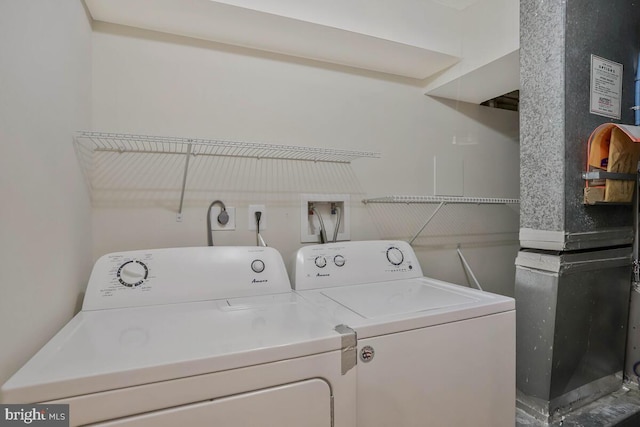 washroom featuring heating unit, laundry area, and independent washer and dryer