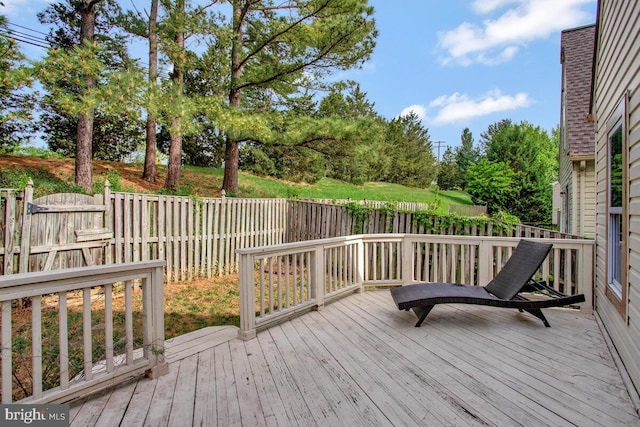 wooden deck with a fenced backyard