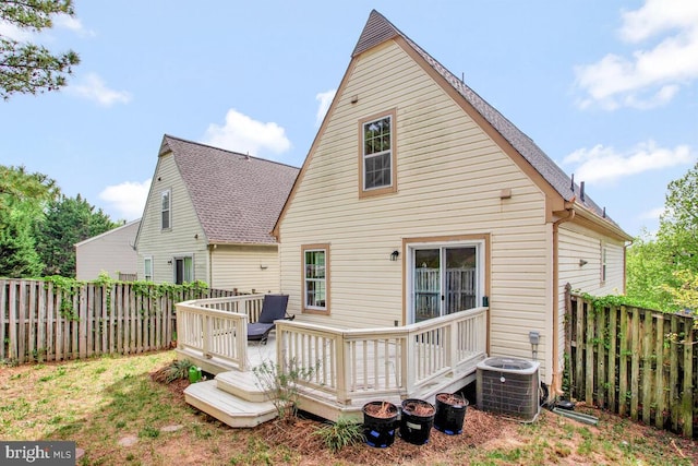 rear view of house with a fenced backyard, central AC, and a deck