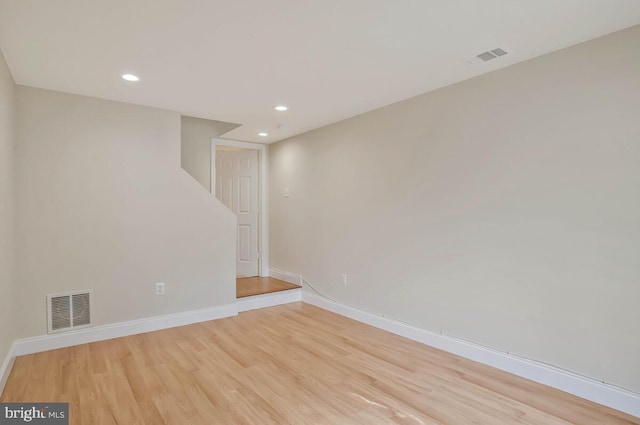 below grade area with light wood-style floors, baseboards, recessed lighting, and visible vents