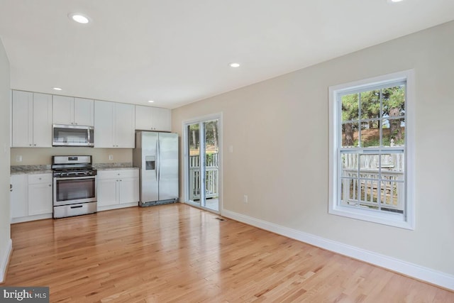 kitchen with light wood-style flooring, a healthy amount of sunlight, and stainless steel appliances