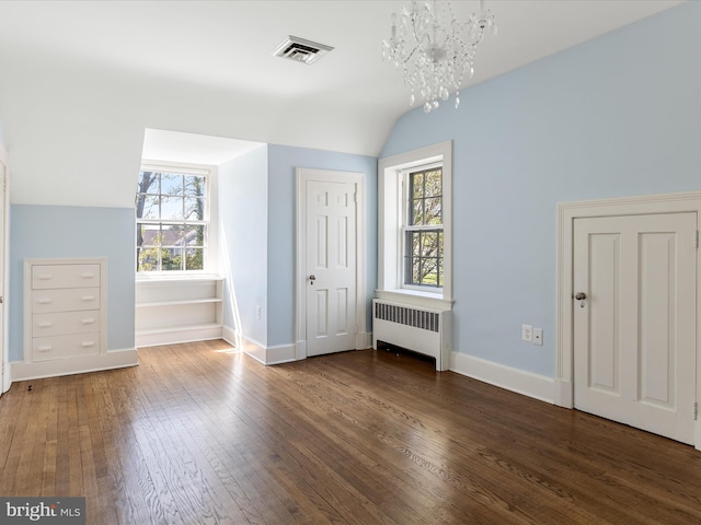 bonus room featuring visible vents, plenty of natural light, radiator, vaulted ceiling, and hardwood / wood-style flooring