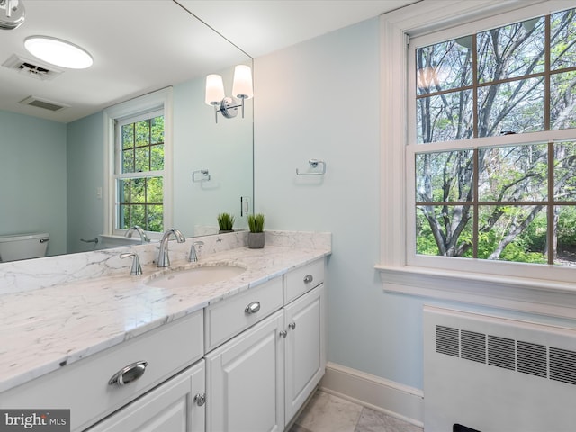 bathroom featuring radiator heating unit, baseboards, toilet, and visible vents