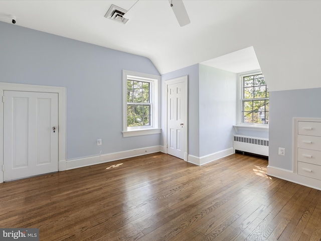 unfurnished bedroom featuring visible vents, radiator, lofted ceiling, and multiple windows