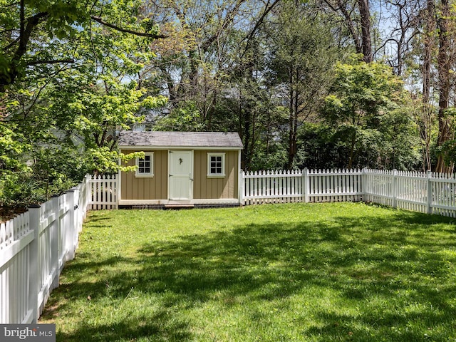 view of yard featuring a fenced backyard, an outbuilding, and a shed