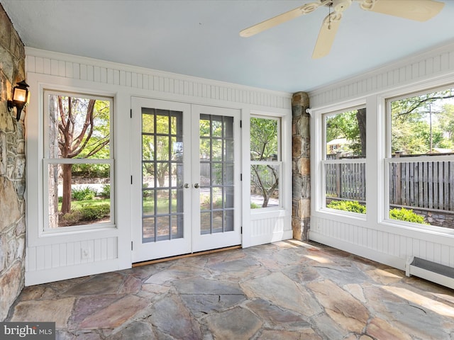unfurnished sunroom featuring stone flooring, a healthy amount of sunlight, and french doors