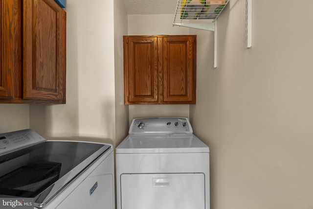 laundry room featuring separate washer and dryer and cabinet space