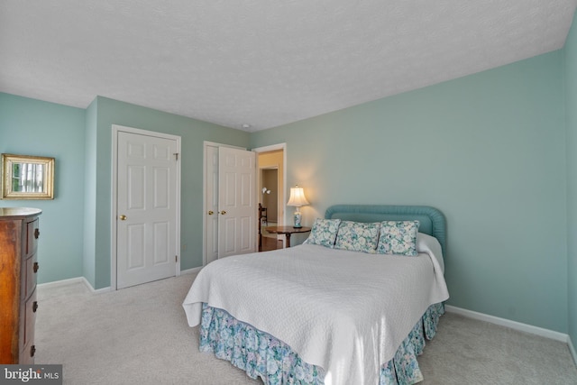 carpeted bedroom with baseboards and a textured ceiling
