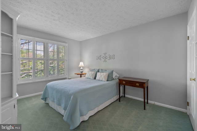 carpeted bedroom featuring baseboards and a textured ceiling