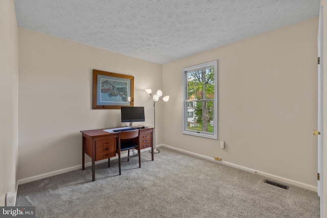 office featuring carpet floors, a textured ceiling, baseboards, and visible vents