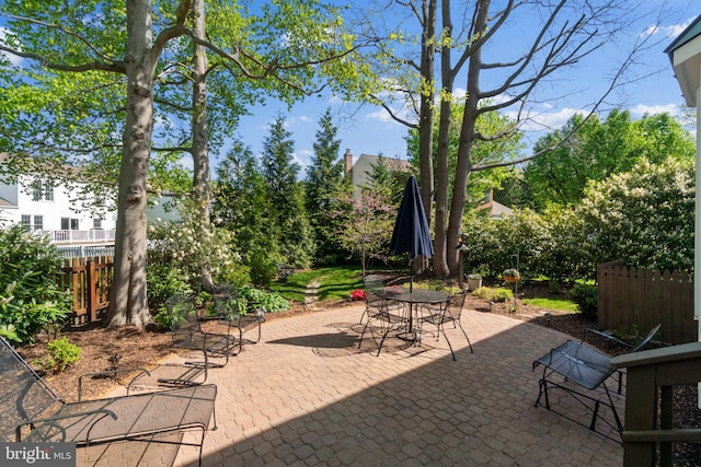 view of patio with outdoor dining area and fence
