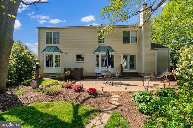 back of property featuring a patio area, a chimney, and entry steps