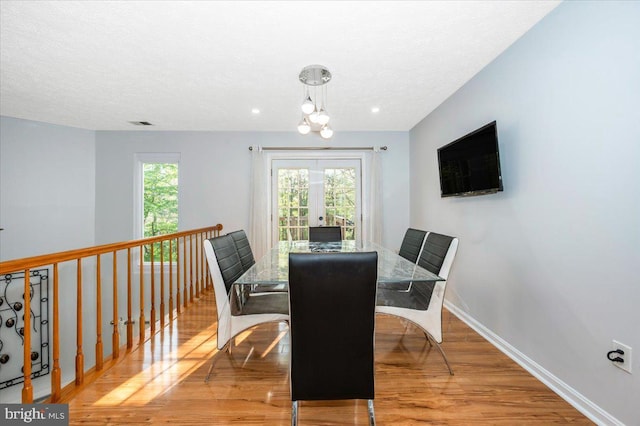 dining area with baseboards, wood finished floors, and a textured ceiling