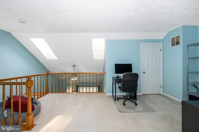 carpeted office with a textured ceiling, visible vents, baseboards, and a skylight