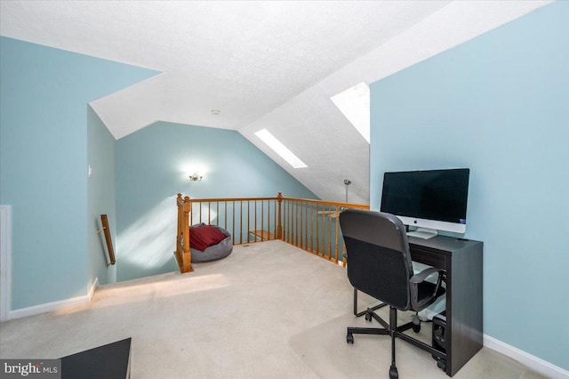 carpeted home office with a textured ceiling and vaulted ceiling with skylight