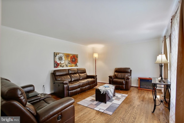 living room with crown molding, wood finished floors, and baseboards