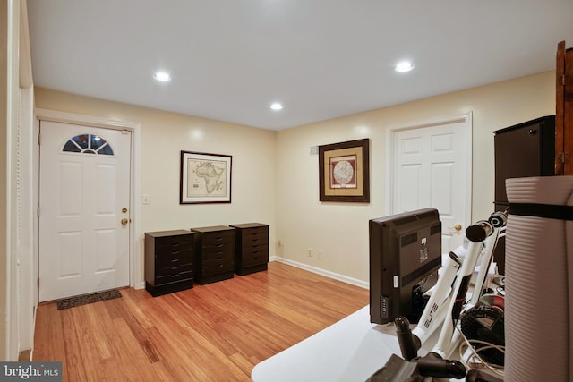 workout area featuring recessed lighting, baseboards, and light wood-type flooring