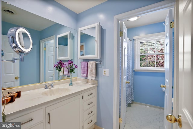 full bathroom with tile patterned floors, a shower with shower curtain, vanity, baseboards, and visible vents