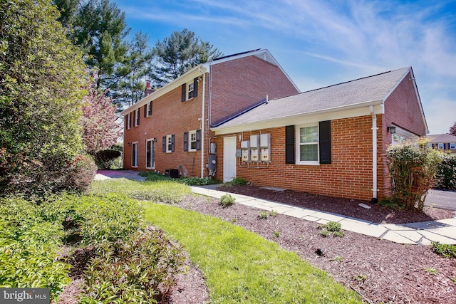 exterior space featuring cooling unit and brick siding