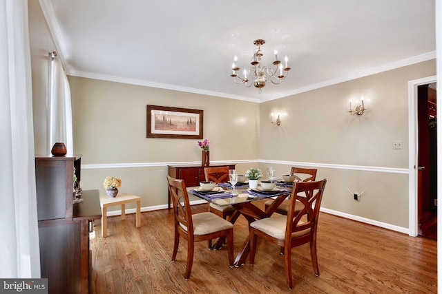 dining room with baseboards, wood finished floors, an inviting chandelier, and crown molding