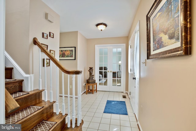 tiled entryway with french doors, stairs, and baseboards