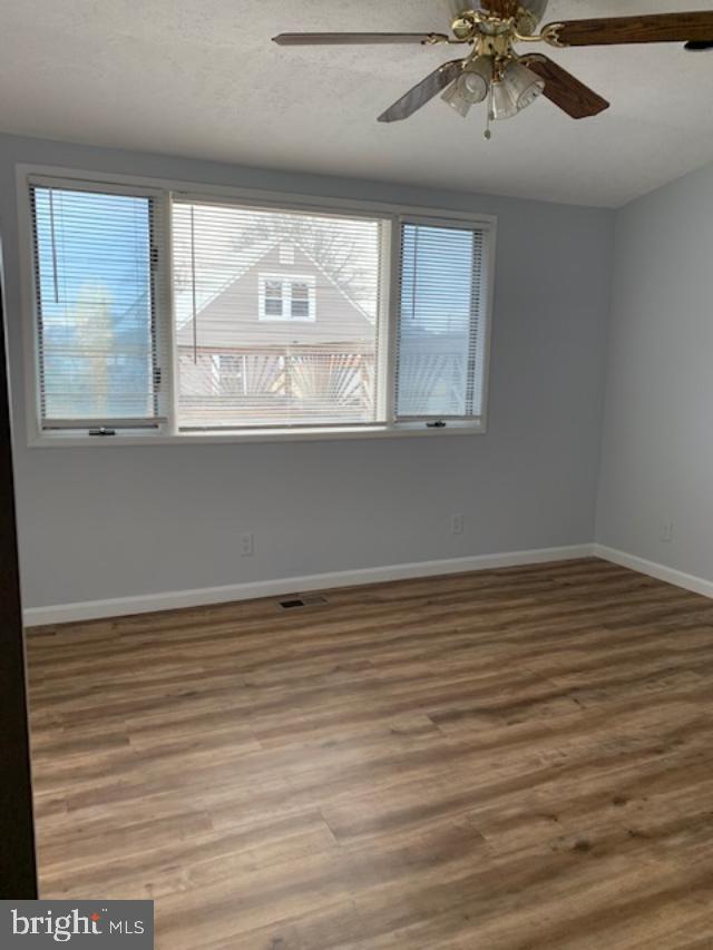 515 Wood St, Baltimore, MD 21225 - spare room with wood finished floors, baseboards, and ceiling fan
