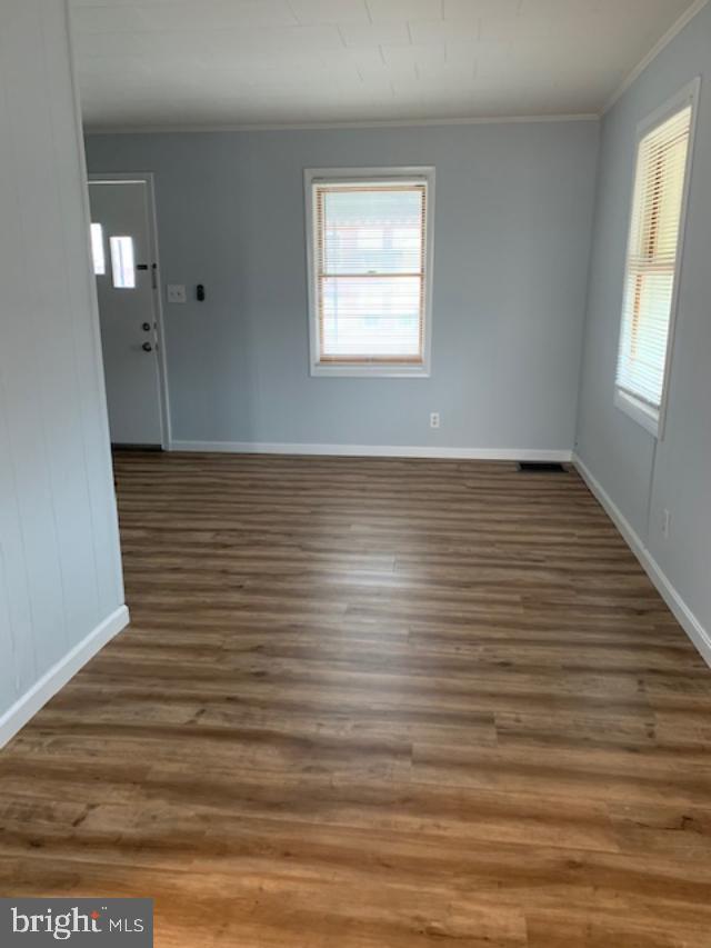 515 Wood St, Baltimore, MD 21225 - empty room with crown molding, wood finished floors, and baseboards