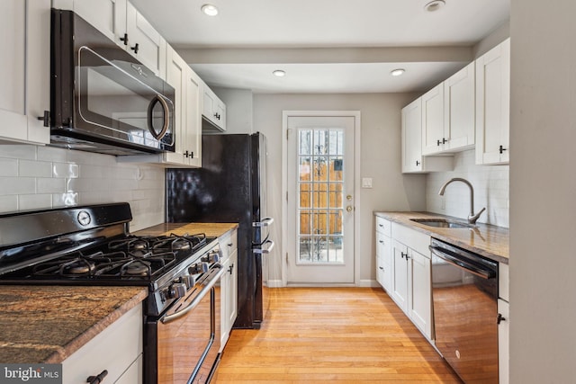 1720 Alter St, Philadelphia, PA 19146 - kitchen featuring light wood-style floors, white cabinetry, a sink, and black appliances