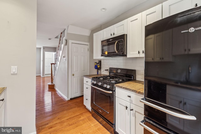 1720 Alter St, Philadelphia, PA 19146 - kitchen featuring white cabinets, baseboards, light wood-style floors, decorative backsplash, and black appliances