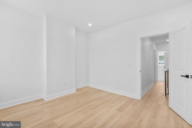 empty room with recessed lighting, light wood-type flooring, and baseboards