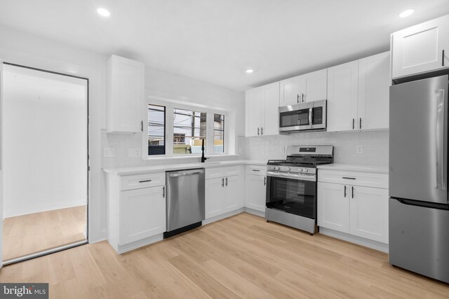 kitchen with light countertops, white cabinetry, light wood finished floors, and stainless steel appliances