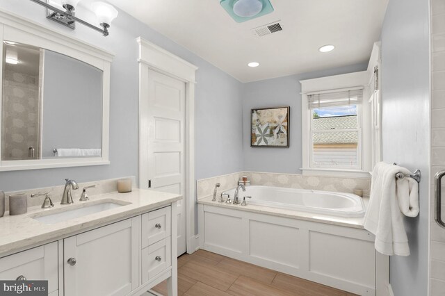 3915 Aspen St, Chevy Chase, MD 20815 - bathroom with a tile shower, a garden tub, visible vents, vanity, and wood finish floors