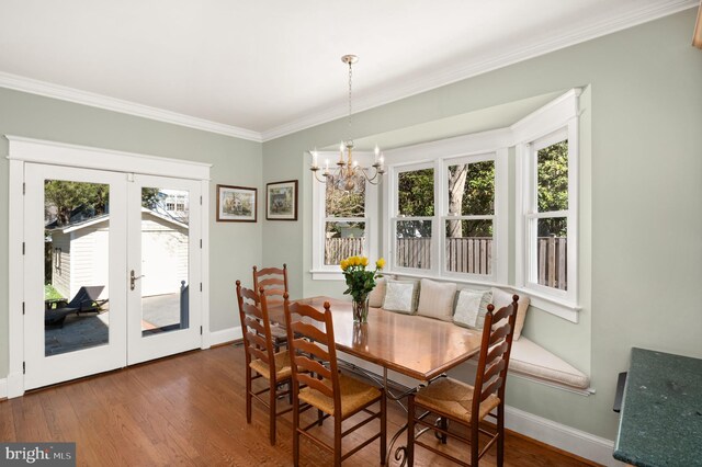 3915 Aspen St, Chevy Chase, MD 20815 - dining area featuring wood finished floors, a notable chandelier, ornamental molding, and a healthy amount of sunlight