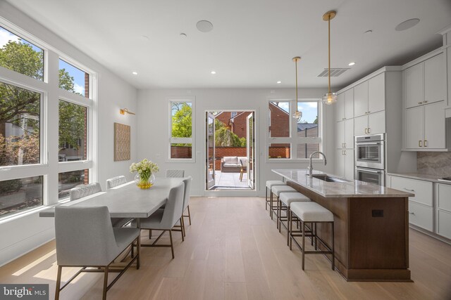 227 S Union St, Alexandria, VA 22314 - kitchen featuring stainless steel double oven, plenty of natural light, a sink, and an island with sink