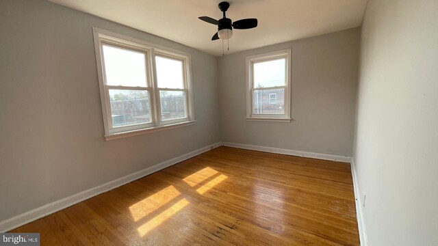 spare room with baseboards and light wood-style floors