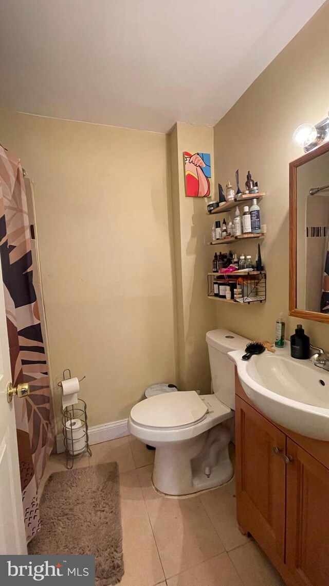 bathroom with tile patterned floors, vanity, curtained shower, and toilet