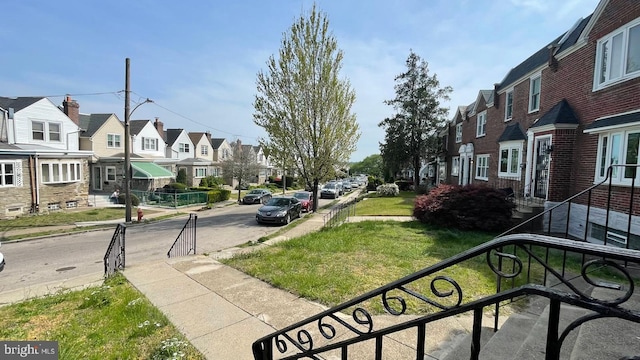 view of street with street lighting, a residential view, curbs, and sidewalks