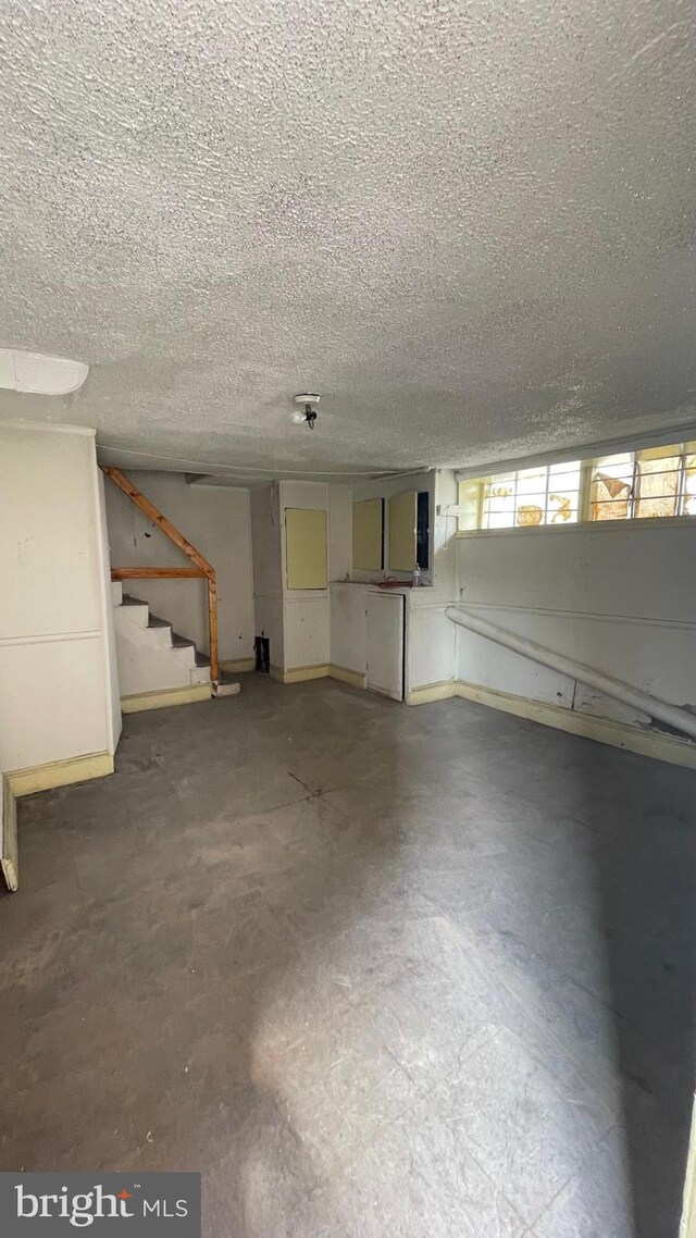 basement with stairs and a textured ceiling