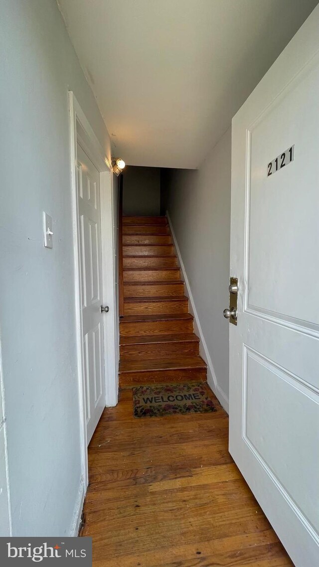 stairs featuring wood finished floors and baseboards