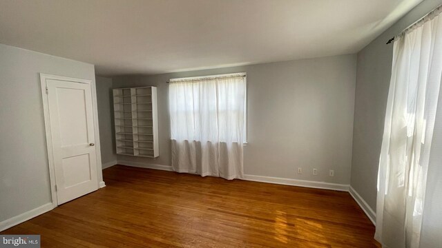 unfurnished bedroom featuring baseboards and wood finished floors