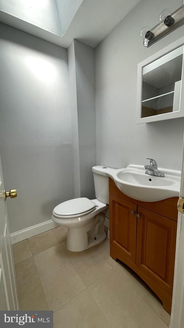 bathroom featuring toilet, vanity, and tile patterned floors