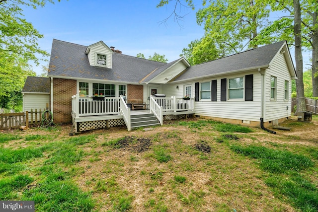 cape cod-style house with fence, central AC, brick siding, a deck, and a chimney