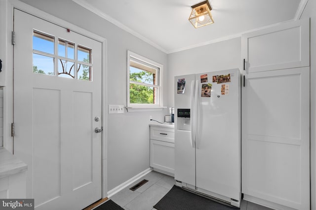 doorway with baseboards, visible vents, ornamental molding, and light tile patterned floors