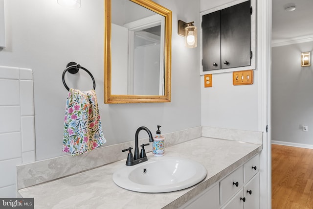 bathroom featuring vanity, ornamental molding, and wood finished floors