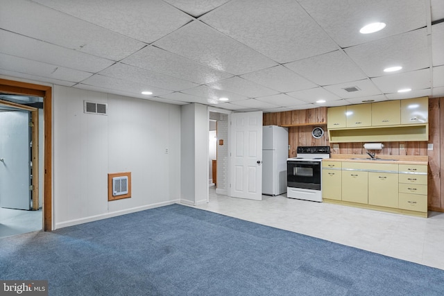 kitchen featuring visible vents, cream cabinets, light countertops, freestanding refrigerator, and electric stove