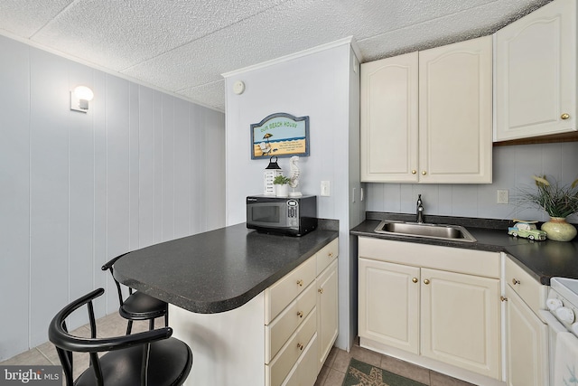 12808 Coastal Hwy Unit 206, Ocean City, MD 21842 - kitchen with electric range, dark countertops, a sink, stainless steel microwave, and a peninsula
