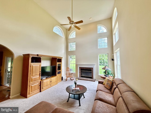 14100 Twisting Ln, Dayton, MD 21036 - living area featuring ceiling fan, a high ceiling, arched walkways, light carpet, and a fireplace