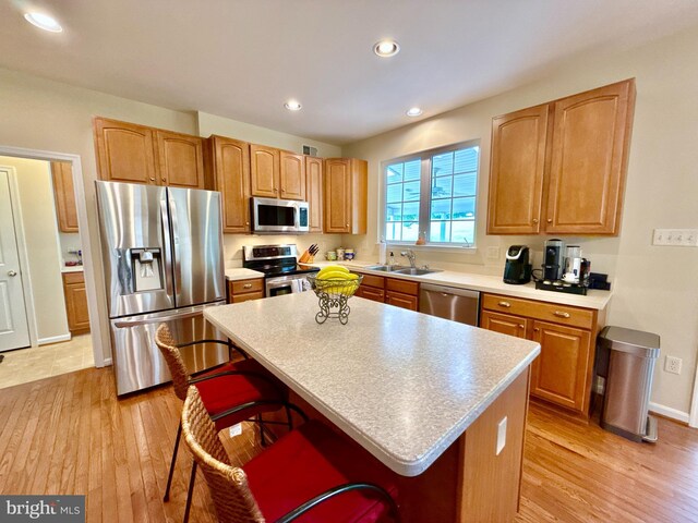 14100 Twisting Ln, Dayton, MD 21036 - kitchen with appliances with stainless steel finishes, light wood-type flooring, light countertops, a breakfast bar area, and recessed lighting